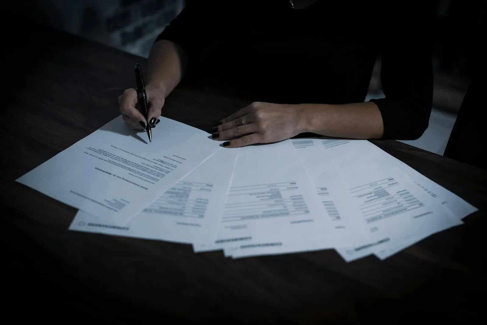 Специалист считает расходы, разложив документы на столе